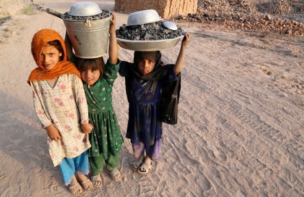 Afghan girls working at a brick manufacturer with buckets of stones on the outskirts of Kabul, Afghanistan